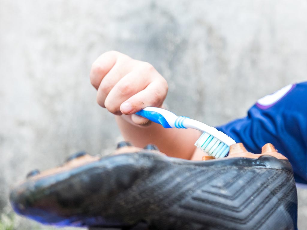 Cleaning football boots with brush